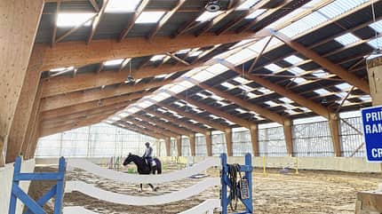 Ondex, PVC-Platte, Lichtplatte, Tageslichtband, Reithalle, Reitsportanlage, Dachkonstruktion, Holzleimbinder, Innenraum, Pferdesport Das Foto zeigt eine Reithalle mit in die Dachkonstruktion integrierten lichtdurchlässigen PCV-Platten des Herstellers Ondex.