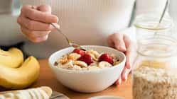 Eine Frau isst ein Haferflocken-Porridge mit einem Obst-Topping