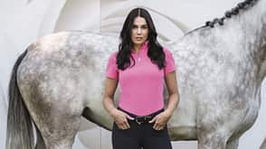 Funktionskleidung, pinkes Shirt, Funktionsshirt, Reitmode, Schockemöhle, Reitbekleidung Junge Frau vor einem Schimmel mit pinkem Funktionsshirt von Schockemöhle
