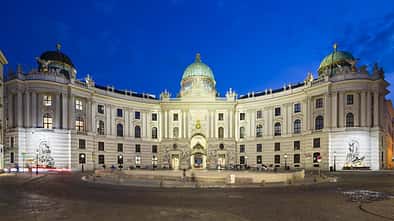 Die Spanische Hofreitschule in der Hofburg am Michaelerplatz in Wien, Österreich bei Nacht.