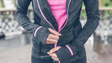 Frau schließt Reißverschluss einer Jacke 