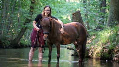 Helene Bockhorst mit ihrer Isländerstute in einem Bach