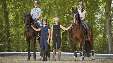 Katharina Hemmer, Gianna Regenrecht, Antonia Baumgart und Anna Den im Gruppenfoto mit zwei Pferden auf einem Reitplatz