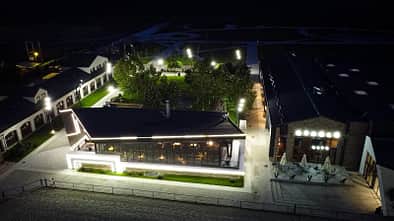 Phoenix Riders, Rumänien, Springreiten, Reitanlage, Turniergelände, Pferdestall Beleuchtung, moderne Reitanlage Stallgebäude und Casino v. Phoenix Riders in Prahova, Rumänien aus der Vogelperspektive bei Nacht