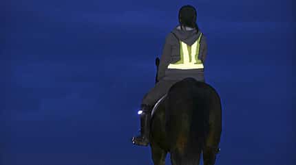 Dunkelheit, Dunkel, Beleuchtung, Reflektor Pferd und Reiterin mit Warnweste im Dunkeln