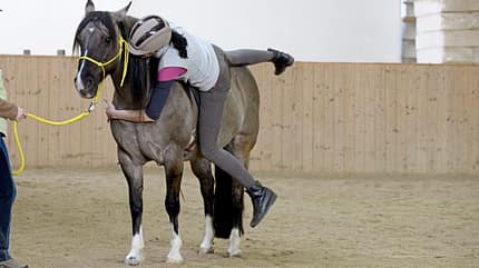 CAVALLO Online Fallkurs, Frau übt abrollen vom Pferd, rutscht seitlich vom Pferd