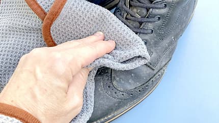 CAVALLO Himmlisch für Putzteufel, Mikrofaser-Tücher von fens, Hand wischt über Wanderschuh mit Mikrofasertuch