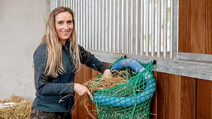 CAVALLO Frischer Wind im Spind, mit Ordnung und Kreativität mehr Platz im Stallschrank, Heunetz an zwei Haken befestigt mit Schwimmnudel in Kreisform in der Öffnung, Heunetz befüllt
