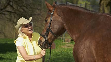 Linda Tellington-Jones, T-Touches, Tellington TTouch Methode Linda Tellington-Jones spricht mit einem braunen Pferd