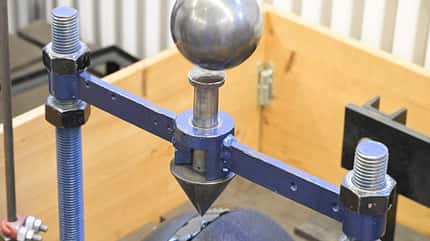 Reithelm-Test, Reithelm Norm, Reithelm TÜV, Helm, uvex, Abus Pikeur, HKM, Cheval de Luxe Eine Metall-Kugel fällt auf einen spitzen Kegel, unter dem der Reithelm liegt