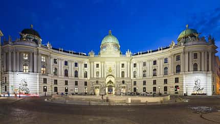 Die Spanische Hofreitschule in der Hofburg am Michaelerplatz in Wien, Österreich bei Nacht.