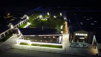 Phoenix Riders, Rumänien, Springreiten, Reitanlage, Turniergelände, Pferdestall Beleuchtung, moderne Reitanlage Stallgebäude und Casino v. Phoenix Riders in Prahova, Rumänien aus der Vogelperspektive bei Nacht