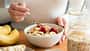 Fitness Food, Snack für den Stall, Reiter Ernährung, gesunde Ernährung für Reiter, Haferflocken, Banane Eine Frau isst ein Haferflocken-Porridge mit einem Obst-Topping