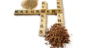 Buchstaben, die in Scrabble-Manier gelegt wurden und die Worte "Nährwert", "Eiweiss" sowie "Pektin" bilden. Drumherum sid kleine Häufchen Pferdefutter drapiert.