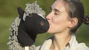 Frau küsst Hobbyhorse-Steckenpferd 