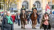 CAVALLO Polizei Reiterstaffel Hannover, zwei Polizistinnen unterhalten sich reitend auf Kaltblutpferden in Fußgängerzone vor dem Bahnhof, viele Passanten ringsherum, Frau mit Handy im Vordergrund