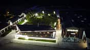 Stallgebäude und Casino v. Phoenix Riders in Prahova, Rumänien aus der Vogelperspektive bei Nacht